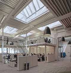 large screens installed on top of the skylight windows of an office building with a modern design