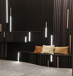 aluminum strip cladding in black covering an interior wall with integrated seating, lighting strips