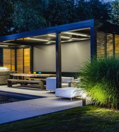 black louvred aluminum pergola at night with lighting, screens, and sliding panels with louvres