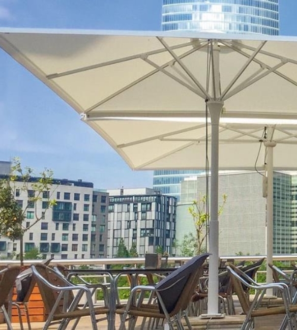 Cream parasols with center post over outdoor café seating