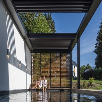 black louvred pergola atop a swimming pool with louvres open letting daylight in