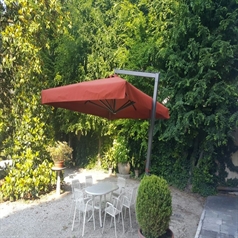 Side arm large red parasol over a backyard patio table