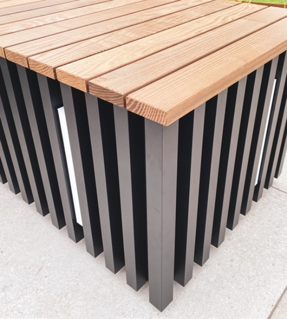 close up of an aluminum seating block with integrated led lighting and a wooden top