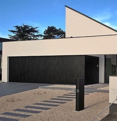 black strip cladding made of aluminum covering the garage door of a residential home in daytime