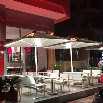 restaurant patio at night with large white umbrellas with a backlit panel integrated