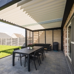 Patio retractable louvered pergola with translucent glass blades incorporated into the louvers