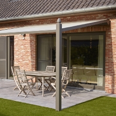 brown and cream pvc pergola with chairs underneath attached to a red brick home
