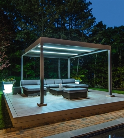 grey aluminum patio cover with louvres and RGB lighting in the night time with furniture underneath
