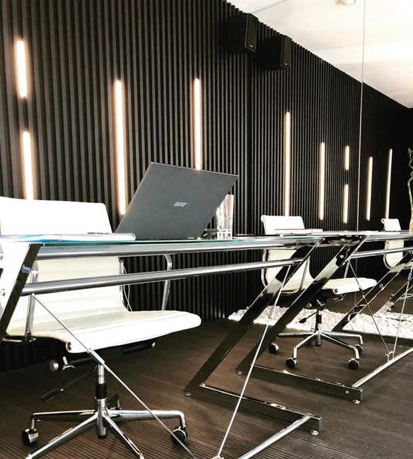 black cladding in black aluminum strips installed on the interior of an office with led light strips