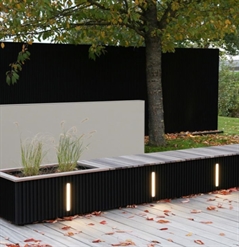 a combined planter and seating unit in black made of aluminum integrated with lighting