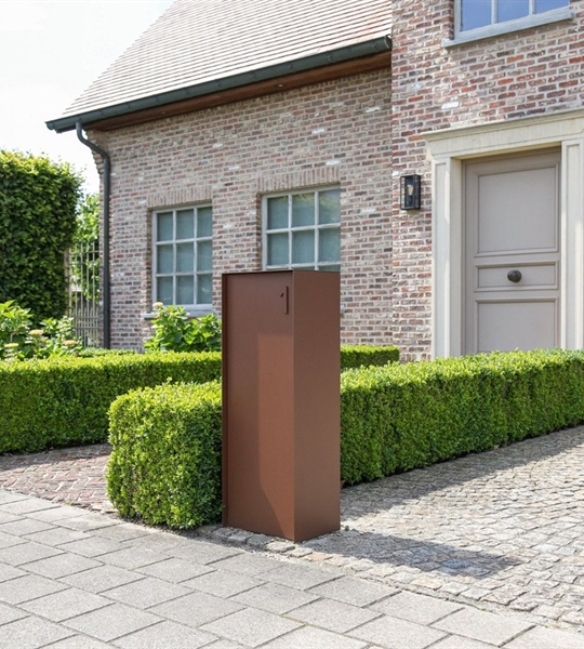 copper coloured aluminum mailbox sitting at the end of a driveway of a classic style brick home