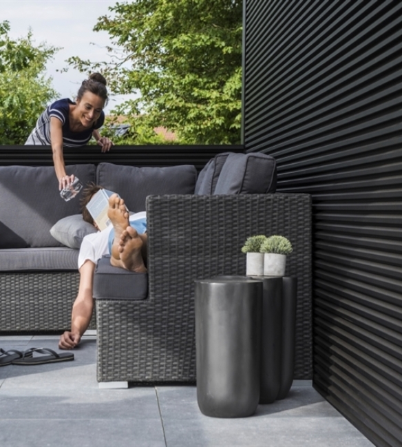 couple frolicking on their patio that has Linius black metal cladding walls