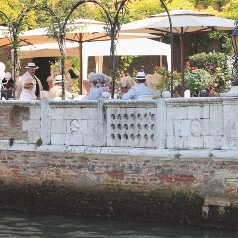 Cream parasols shading and outdoor dining area with people being entertained