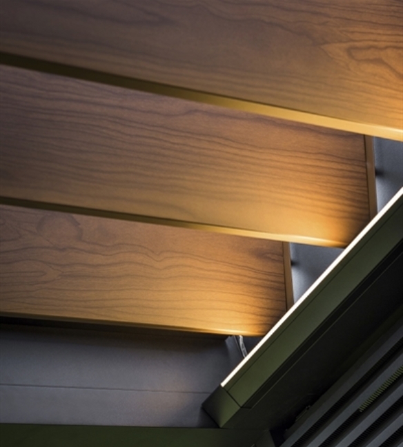 Close up of wood finish aluminum louvers installed in a black pergola