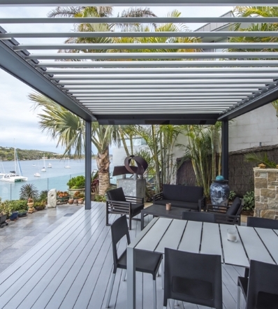 silver bioclimatic pergola with louvres above with a view of the ocean