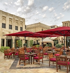 Red centre pole parasols covering a large outdoor dining area
