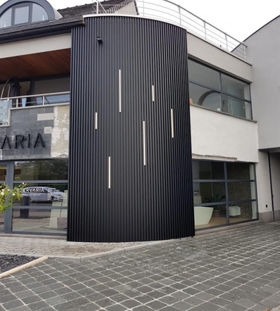 aluminum cladding in black covering a round portion of the exterior of a commercial building