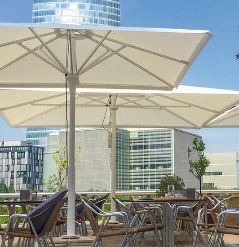 White parasols opened over café seating on a sunny day