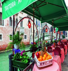 Green parasols over outdoor dining seating area along canal