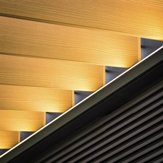 Close up of wood finish aluminum louvers installed in a black louvered pergola