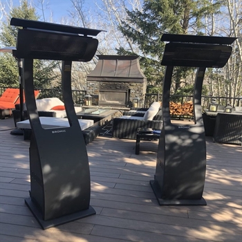 black portable outdoor heaters turned off sitting on an outdoor patio poolside