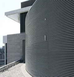 dark grey aluminum cladding that is horizontal covering a curved wall of an office building