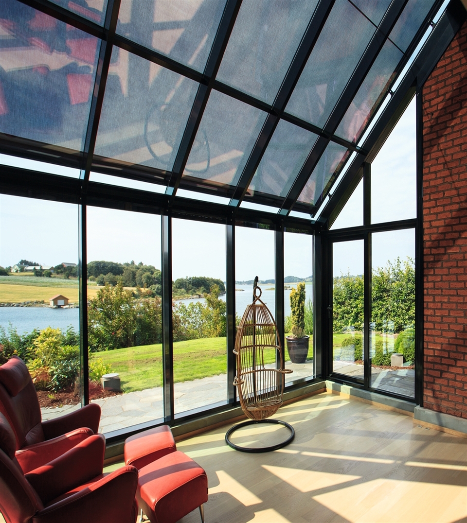 black external roller blind installed on top of a large residential glass awning