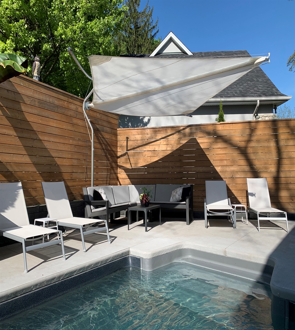 Corradi Defense motorized shade sail with stainless frame beside a pool deck