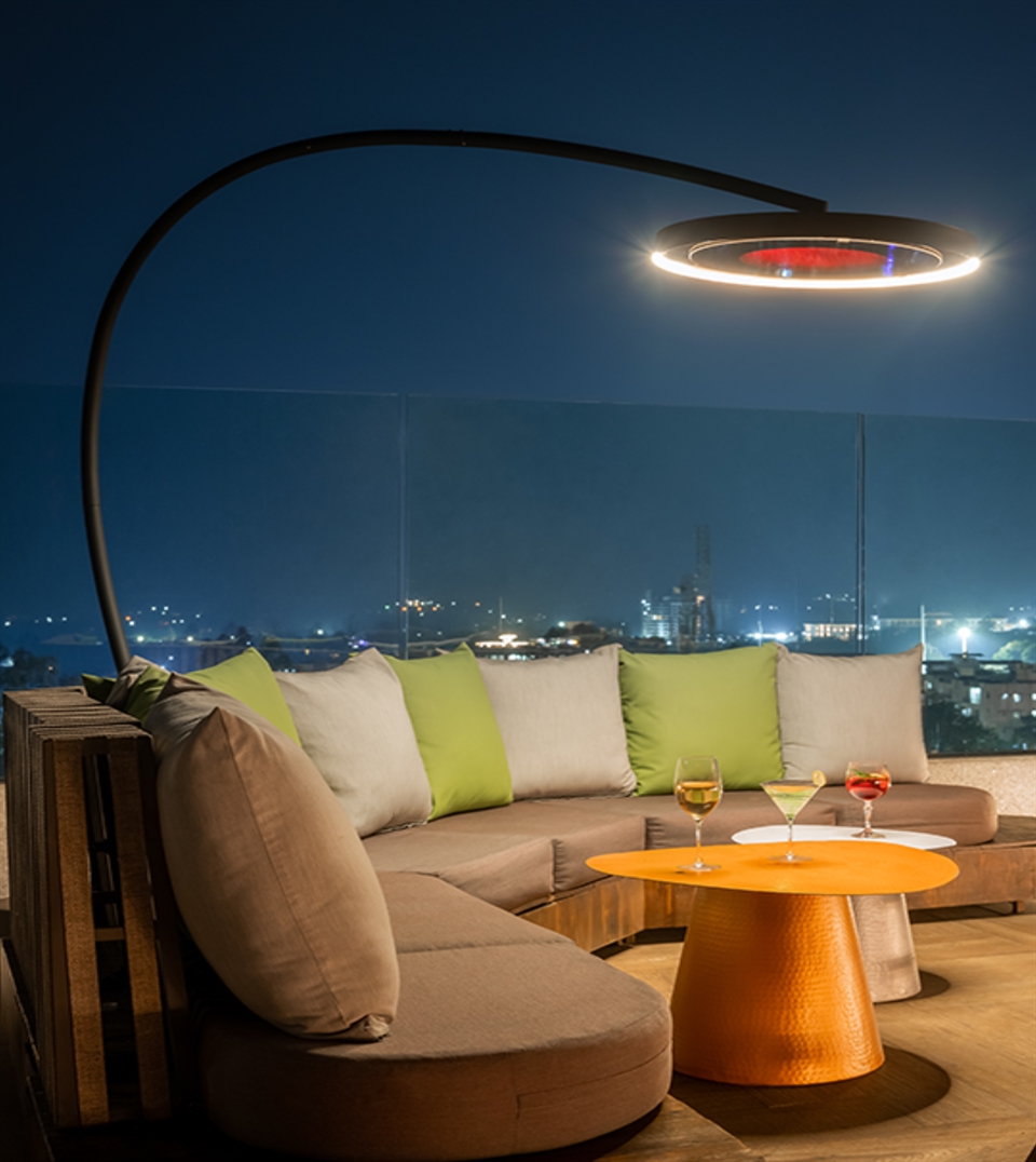 Outdoor floor heater over rooftop lounge at night.