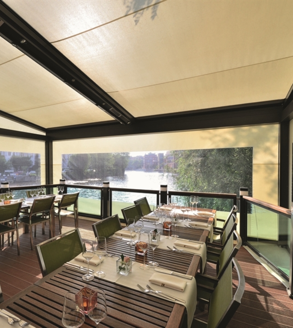 beige patio screens with a crystal window strip enclosing an outdoor restaurant patio