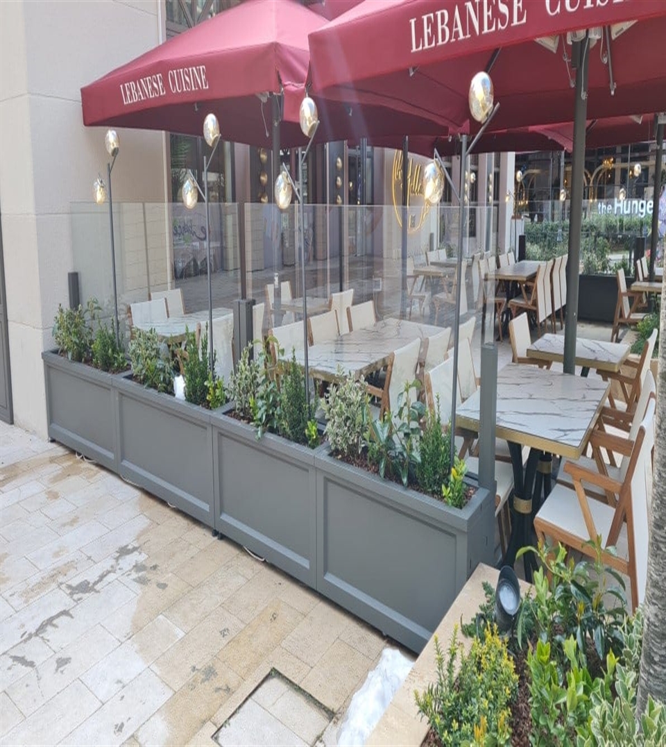 Retractable vertical glass windows by Miba protecting an outdoor patio.