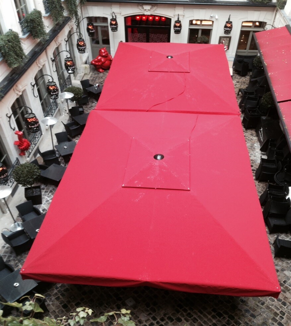 Row of Gaggio MaxiPro umbrellas providing expansive shade for a commercial terrace.