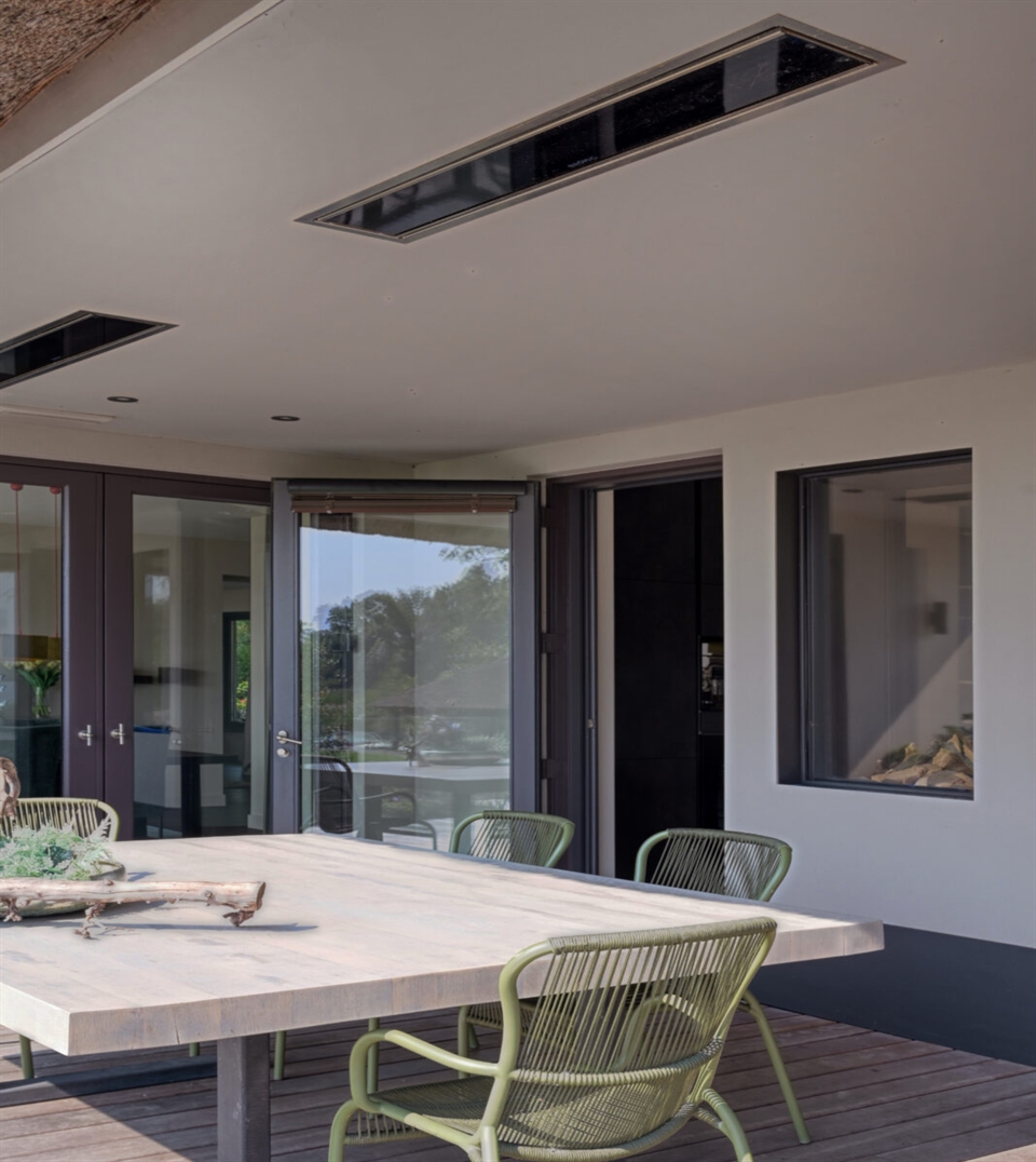 Ceiling-mounted patio heaters above a modern outdoor dining area