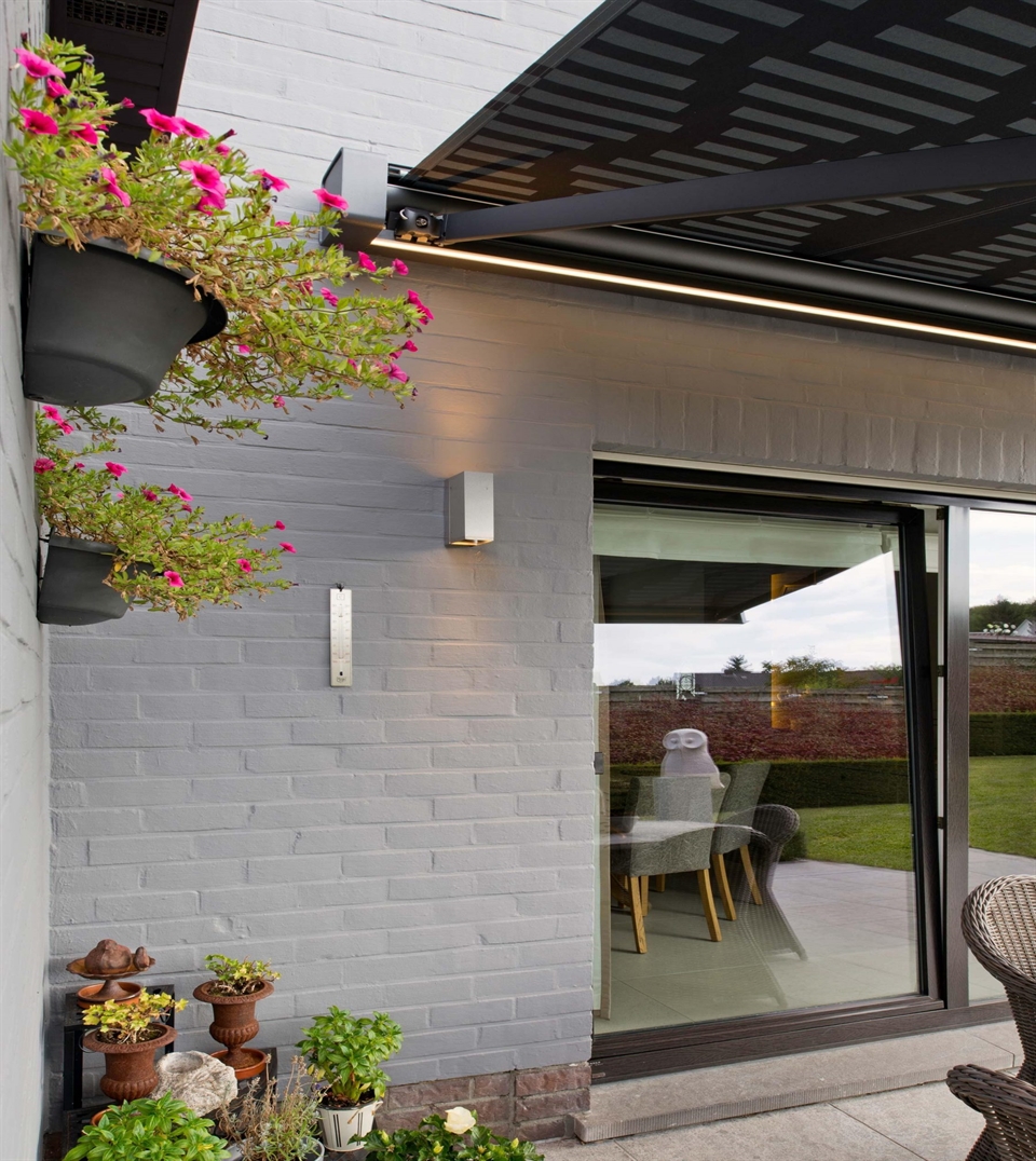 Side view of a modern patio with a sleek retractable awning featuring integrated LED lighting