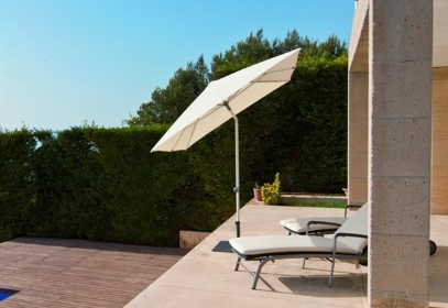 A white umbrella on the patio of a private residence tilted at an angle