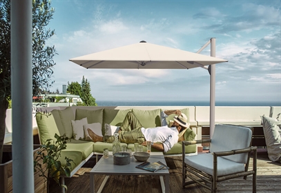 Side pole umbrella with white fabric & a gentleman sleeping on a sofa under