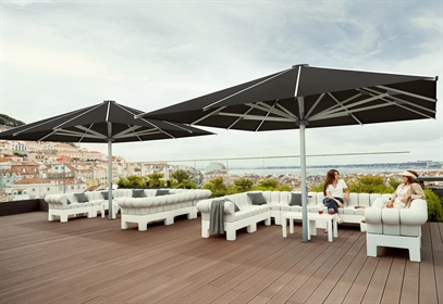 2 large black umbrellas on a rooftop patio overlooking the city