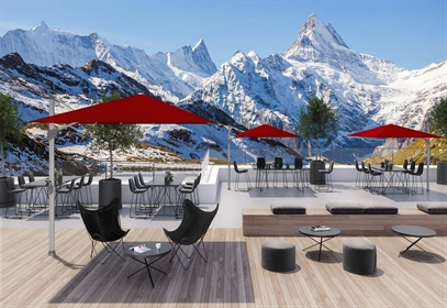 An outdoor patio near the mountains with modern furniture & red umbrellas