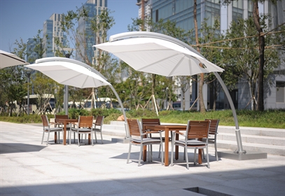 Umbrosa Icarus umbrella in white fabric installed in a public outdoor patio