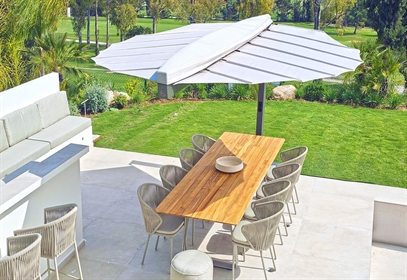The architectural Heatsail LEAF providing shade and misting cooling on a luxury patio.