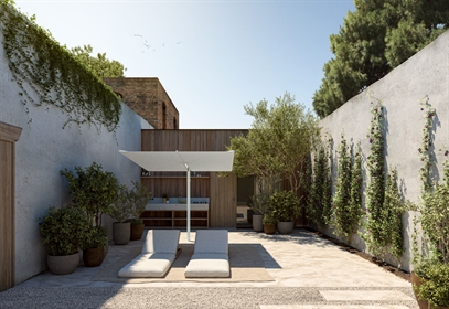 A white parasol in a backyard area covering 2 chairs