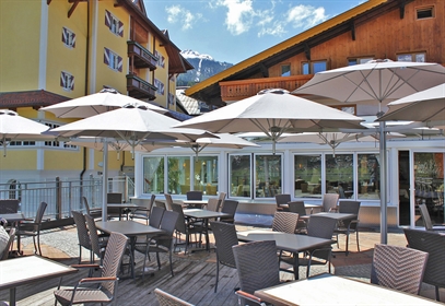 A series of white umbrellas covering a restaurant patio on a sunny day