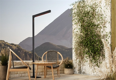 Heatsail TWIG floor lamp on a terrace with woven lounge chairs