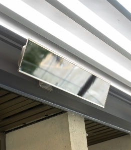 Bromic electric heater in black mounted on the inside frame of a black pergola system