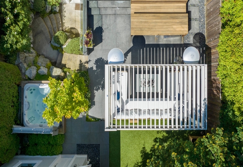 Birds eye view of a white louvered pergola in a residential backyard 