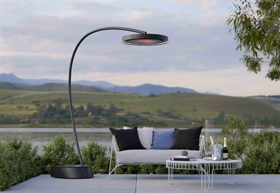 Elegant freestanding outdoor lamp arching over a lakeside seating area