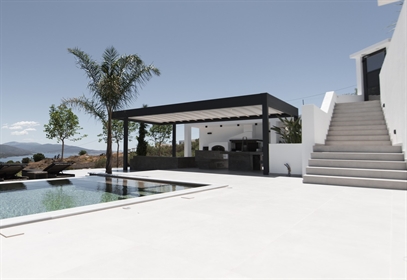 Modern poolside lounge with pergola and lake view.  