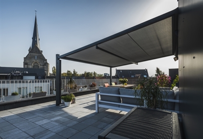 black retractable awning attached to building on apartment penthouse patio