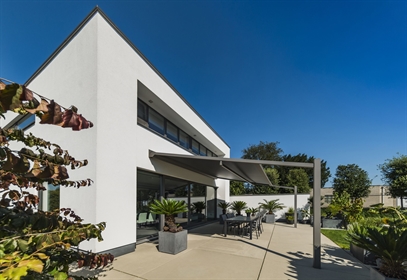 Modern patio with retractable awning and outdoor dining area. 