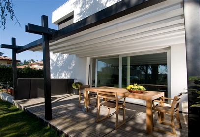 A wall mounted pergola with a unique shape on a residential patio